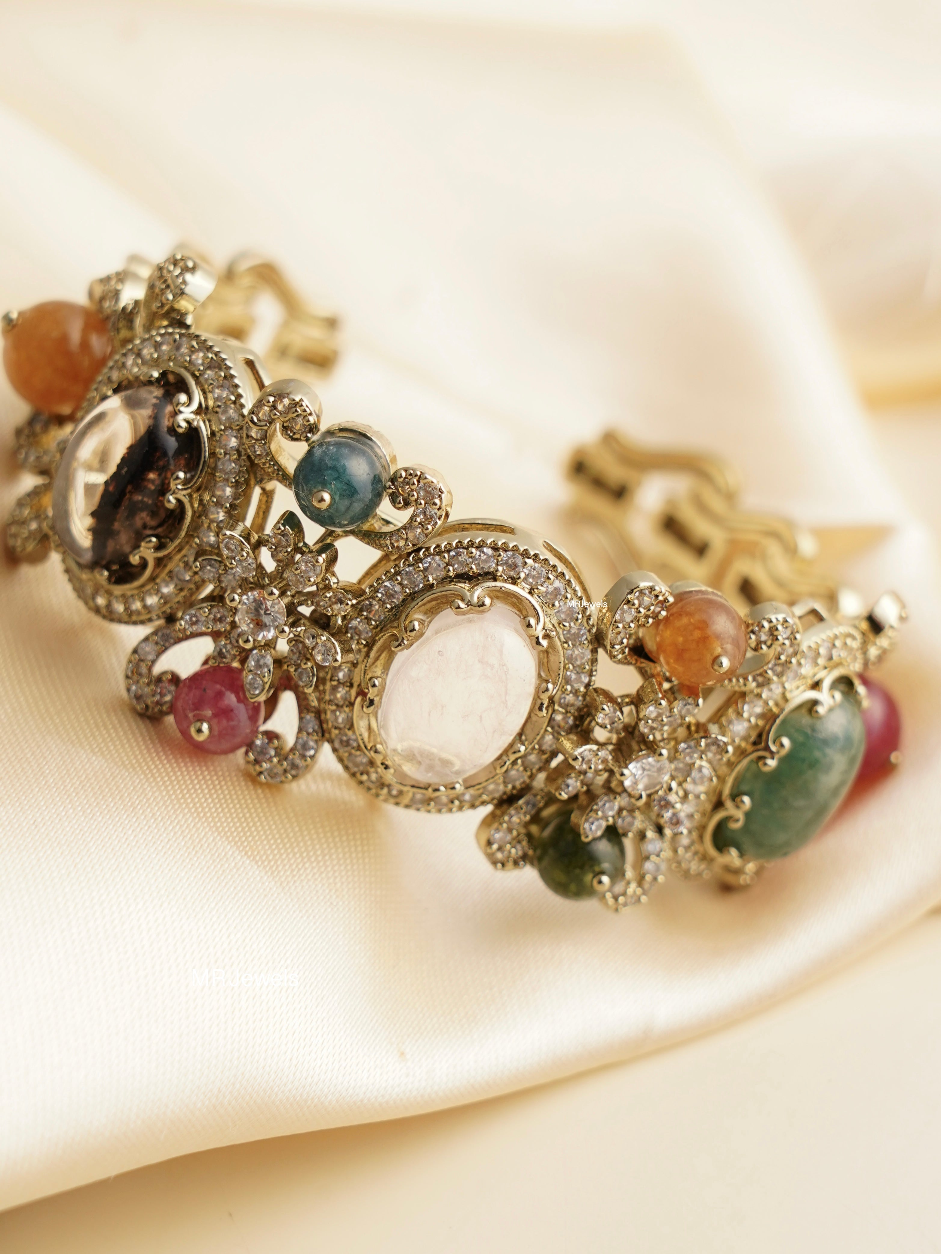 Front view of navratna kada with antique gold finish and heritage-inspired multicolor stones